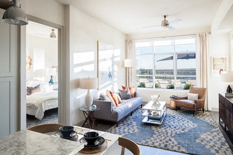 a living room with a couch and a table in front of a window